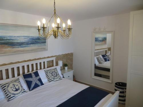 a bedroom with a bed and a chandelier at Stunning Ocean Views in Puerto de Mogan in Puerto de Mogán