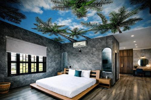 a bedroom with a bed with a ceiling with palm trees at HELLO VILLA & SPA in Hue