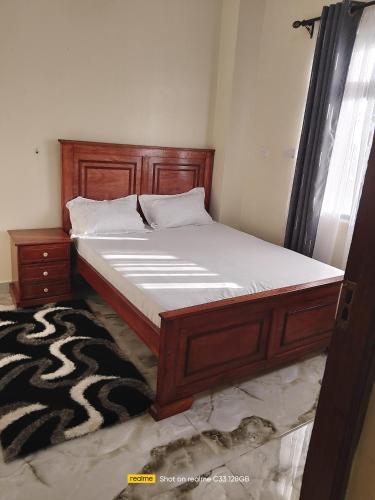 a bed in a bedroom with a wooden bed frame at Luxury Homes in Mtwapa