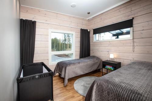 a bedroom with two beds and a tv in it at Villa Kannas 1 in Juuka