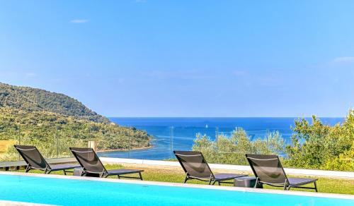 Eine Gruppe von Stühlen steht neben einem Schwimmbecken in der Unterkunft Myrtus Agropoli in Agropoli