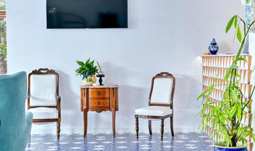 ein Zimmer mit zwei Stühlen, einem Tisch und einem Fernseher in der Unterkunft Myrtus Agropoli in Agropoli