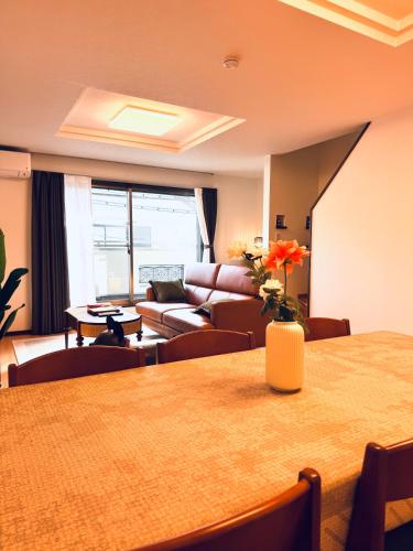 a living room with a table and a couch at 四季歓居-新裝三層一戶建電車直達關西機場難波心斎橋天王寺住吉大社徒歩圏3ldk貸切 in Osaka