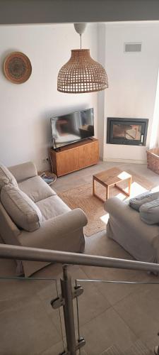 a living room with two couches and a tv at Casa de Melides in Melides