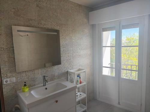 a bathroom with a sink and a mirror and a window at Ezpeleta Palace in Berriozar