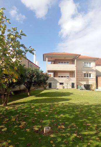a large house with a grass yard in front of it at Casa Playa Meira in Moaña