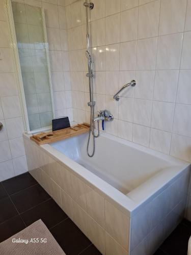 a bath tub in a bathroom with a shower at Ferienwohnung Seeblick in Langweiler
