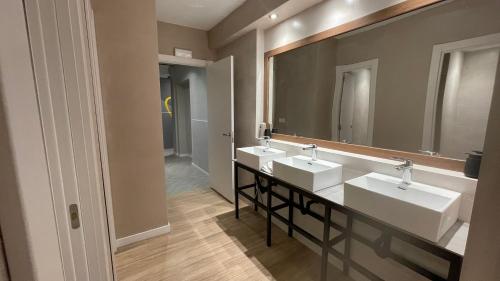 a bathroom with two sinks and a large mirror at Onefam Les Corts in Barcelona