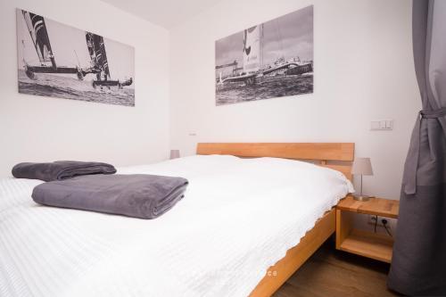 a bedroom with a white bed and a wooden nightstand at Seewind W04 in Laboe