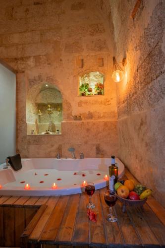 a bath tub with candles and fruit on a wooden table at Born Hotel in Ürgüp