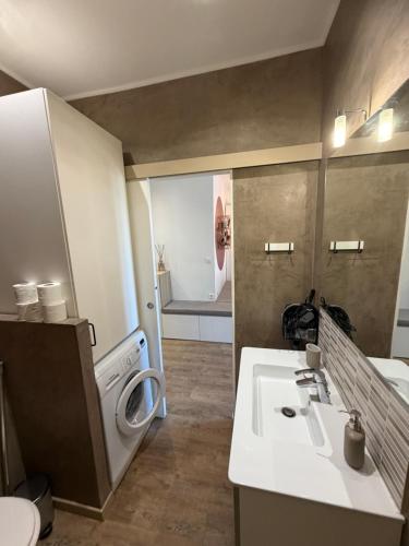 a bathroom with a sink and a washing machine at Elégance du Golfe in Vallauris
