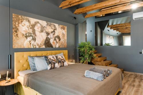 a bedroom with a bed with a large painting on the wall at Greyhouse Apartments in Harkány
