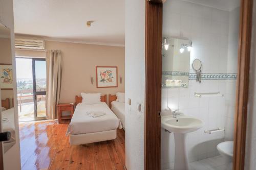ein Hotelzimmer mit Bett und Waschbecken in der Unterkunft Portimão Center Hotel by Umbral in Portimão