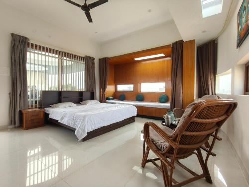 a bedroom with a bed and a chair in it at Aavasan home stay with AC in Dāvangere