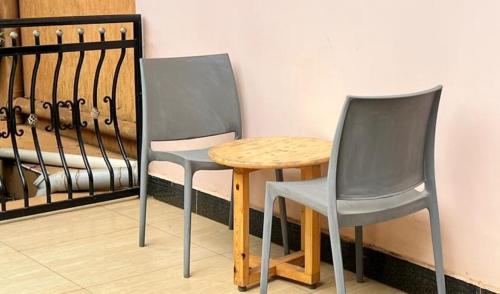 two chairs and a wooden table in a room at Latitudo Suites Uganda in Kajansi
