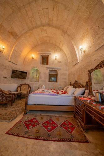 a bedroom with a large bed in a stone room at Born Hotel in Ürgüp