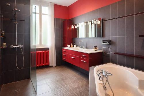 a bathroom with a tub and a sink and a shower at Chez Madame in Dijon