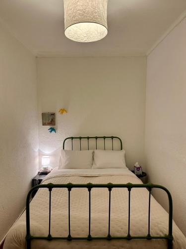 a bedroom with a bed and a light fixture at A cozy cottage in Tomar in Tomar