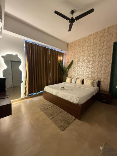 a bedroom with a bed and a ceiling fan at Fifth Heaven Studio at Spectrum Mall in Noida