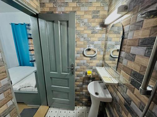 a bathroom with a toilet and a sink and a door at CAMERHOME Lycée Cité des palmiers in Douala