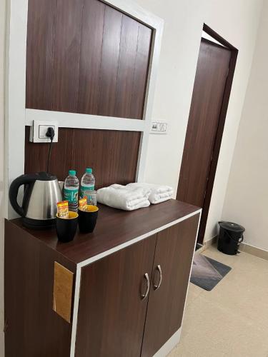 a wooden cabinet with two bottles of water and towels at Hotel Dayalu palace in Vrindāvan