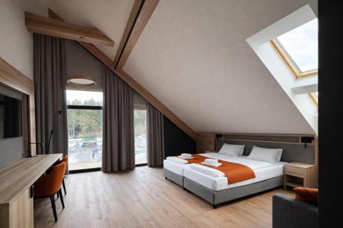 a bedroom with a bed and a large window at Ski and Bike Residence in Istebna