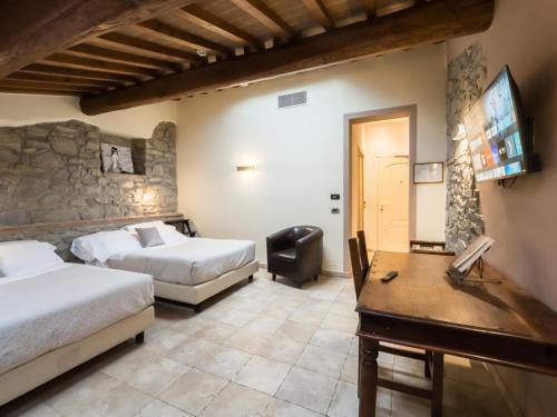 a hotel room with two beds and a flat screen tv at Vogue Hotel Arezzo in Arezzo