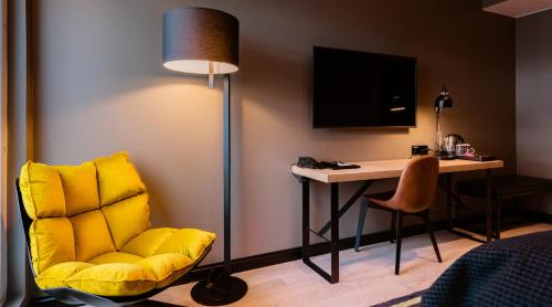 a room with a yellow chair and a desk at Clarion Hotel Aviapolis in Vantaa