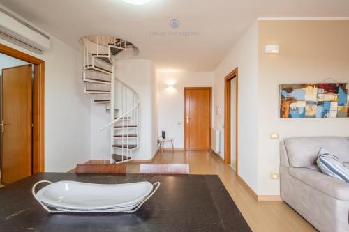 a living room with a couch and a spiral staircase at Domo Mea-House Live Express in Quartu Sant'Elena