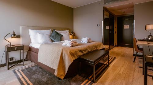 a bedroom with a bed with a table and a desk at Clarion Hotel Aviapolis in Vantaa