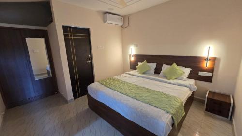 a bedroom with a large bed with green pillows at I Rose Guest House By Olive in Talaulim