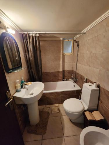 a bathroom with a toilet and a sink and a tub at Cozy Stay in Baabda