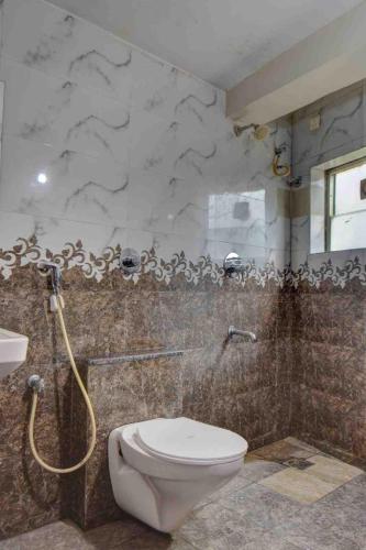 a bathroom with a toilet and a shower at Sai Arya Residency By The Avyaan in Mangalore
