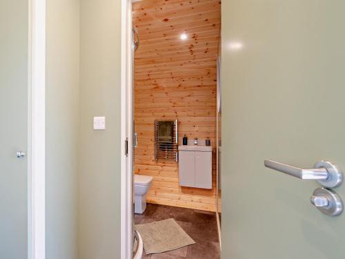 a bathroom with a toilet and a wooden wall at 1 Bed in Matlock oc-96256 in Crich