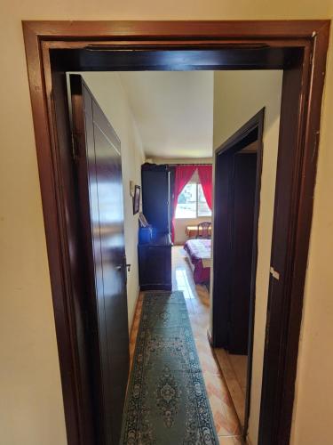 a hallway with a door open to a bedroom at Cozy Stay in Baabda