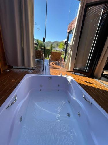 a white bath tub sitting on a deck at Chalé Container Lufre in Santo Antônio do Pinhal