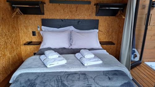 a bed in a room with two towels on it at Chalé Container Lufre in Santo Antônio do Pinhal
