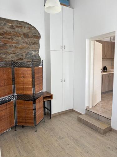 a room with white cabinets and a stone wall at Οικία Χωρας Κυθνου in Kithnos