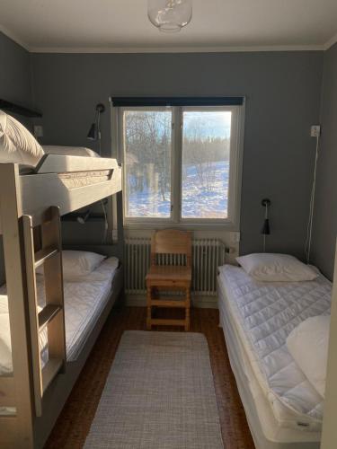 a bedroom with two bunk beds and a window at Lillskarvens vandrarhem in Funäsdalen