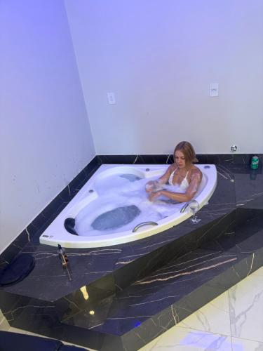 a woman sitting in a jacuzzi tub at Pousada nascer do sol in Portalegre