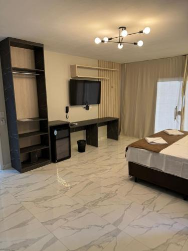 a bedroom with a bed and a flat screen tv at Pousada nascer do sol in Portalegre