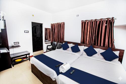 a bedroom with a large bed with blue pillows at Starlight Hotel1Square in Pondicherry