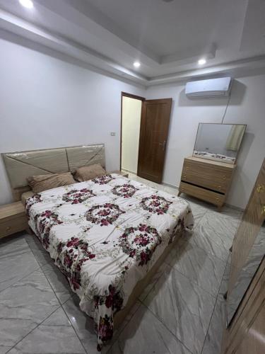 a bedroom with a bed and a mirror and a dresser at Villa 2 in Al Maqārisah