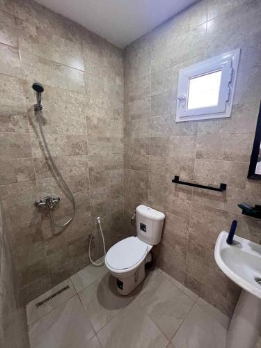 a bathroom with a toilet and a shower and a sink at Villa 2 in Al Maqārisah