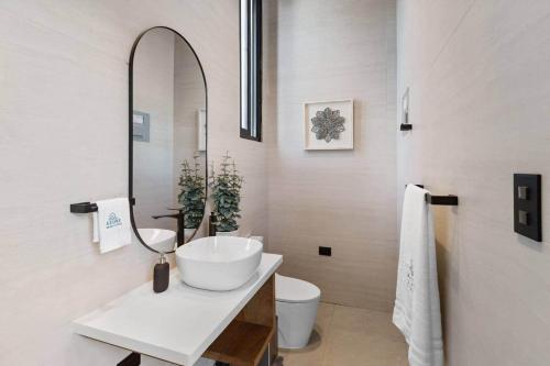 a white bathroom with a sink and a mirror at Beachfront Modern Villa with Pool AZURE in Punta Rucia