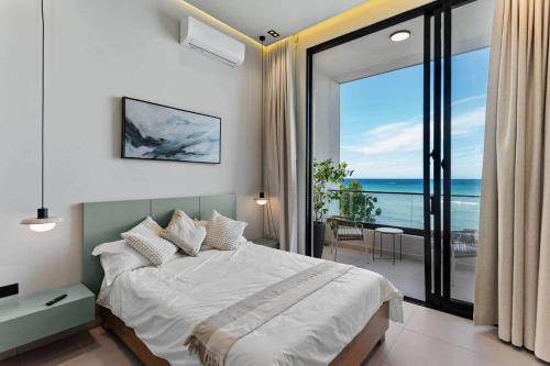 a bedroom with a bed and a view of the ocean at Beachfront Modern Villa with Pool AZURE in Punta Rucia