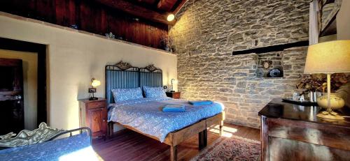 a bedroom with a bed and a stone wall at Ca' d'Alfieri in Bardi