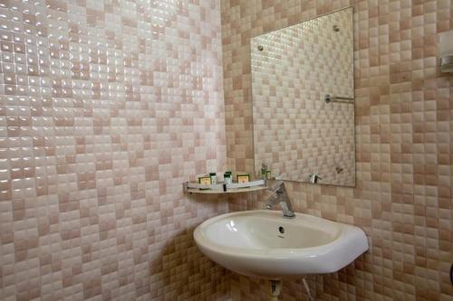 a bathroom with a sink and a mirror at KSTDC Hotel Mayura Krishna Almatti in Bāgalkot