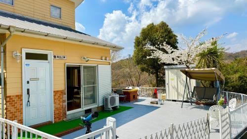 a house with a white fence and a patio at 星光の城 船でアクセス友人との集まりに最適なリラックスできる秘境 in Hinase