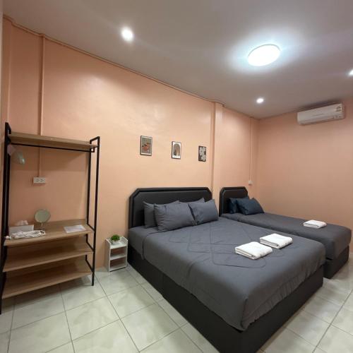a bedroom with a bed with two towels on it at O Pha Suk House in Hat Yai